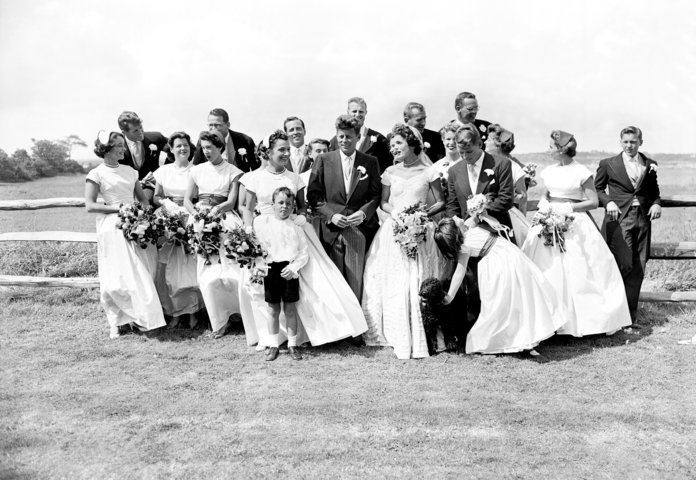 ה couple with their twenty attendants, page boy, and flower girl on their wedding day 