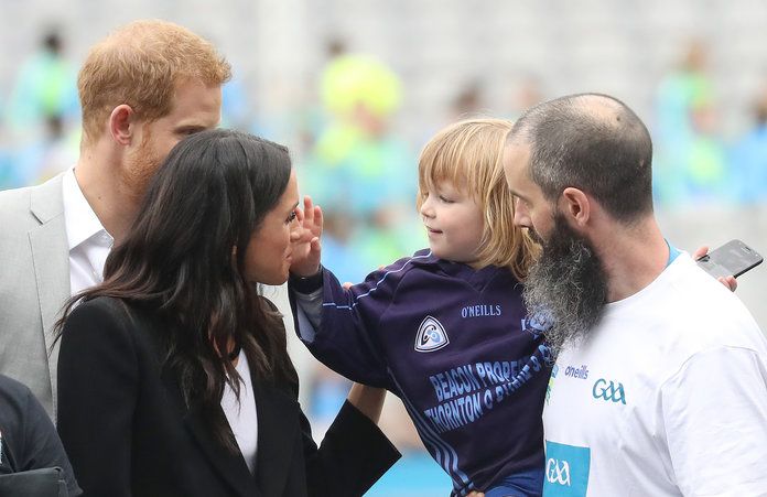 Meghan and Harry with a kid embed 2